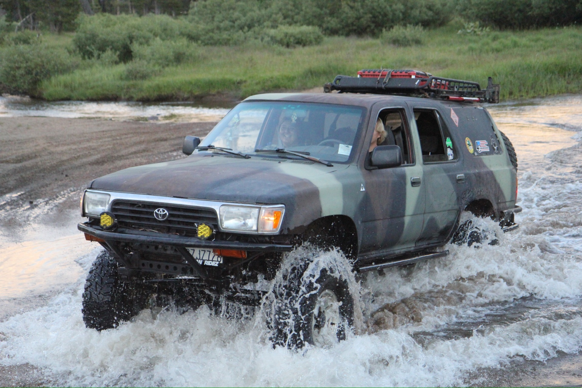 Camo 4Runner blasting through a water crossing