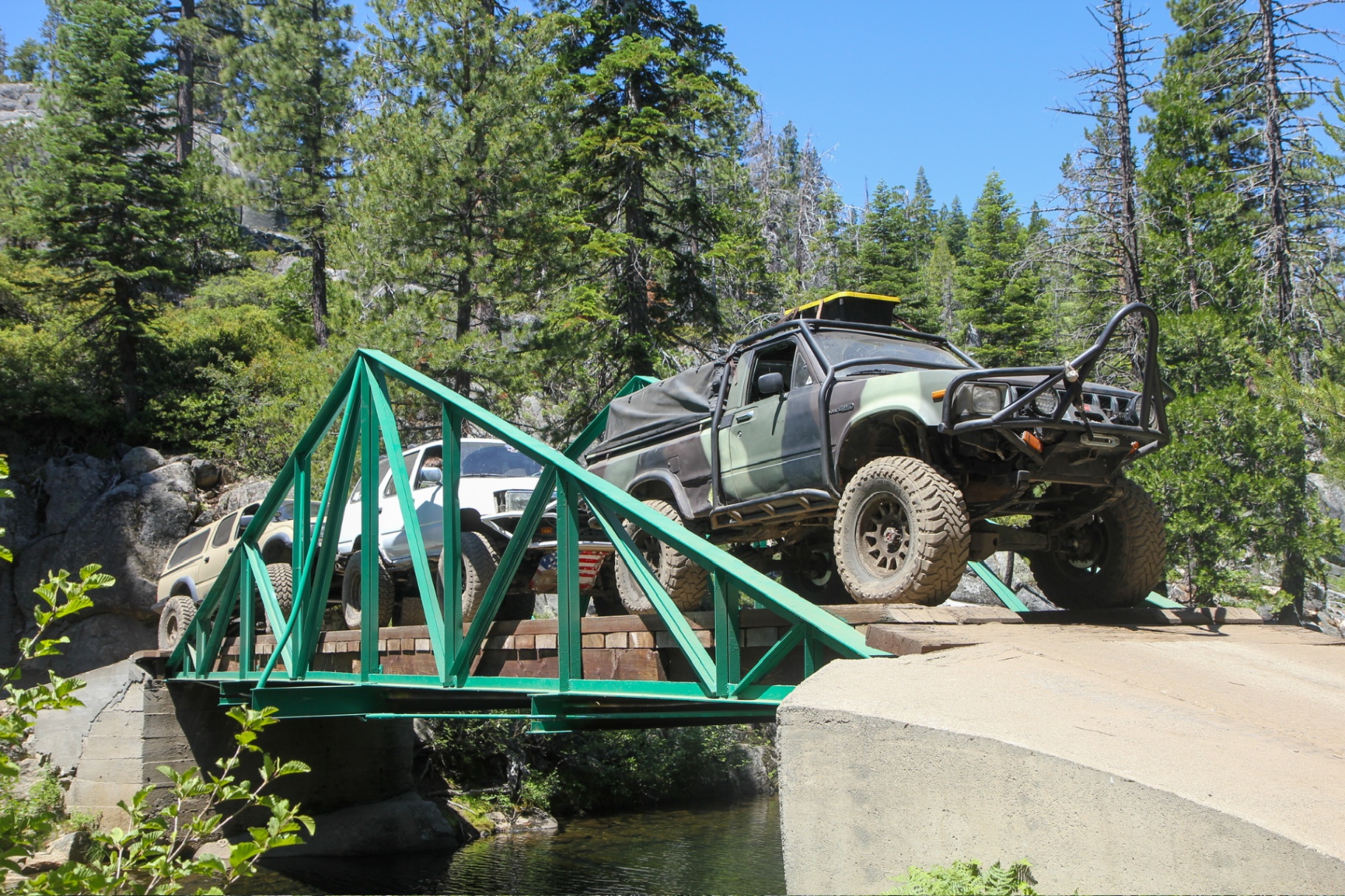 Trucks crossing the green bridge on the Rubicon