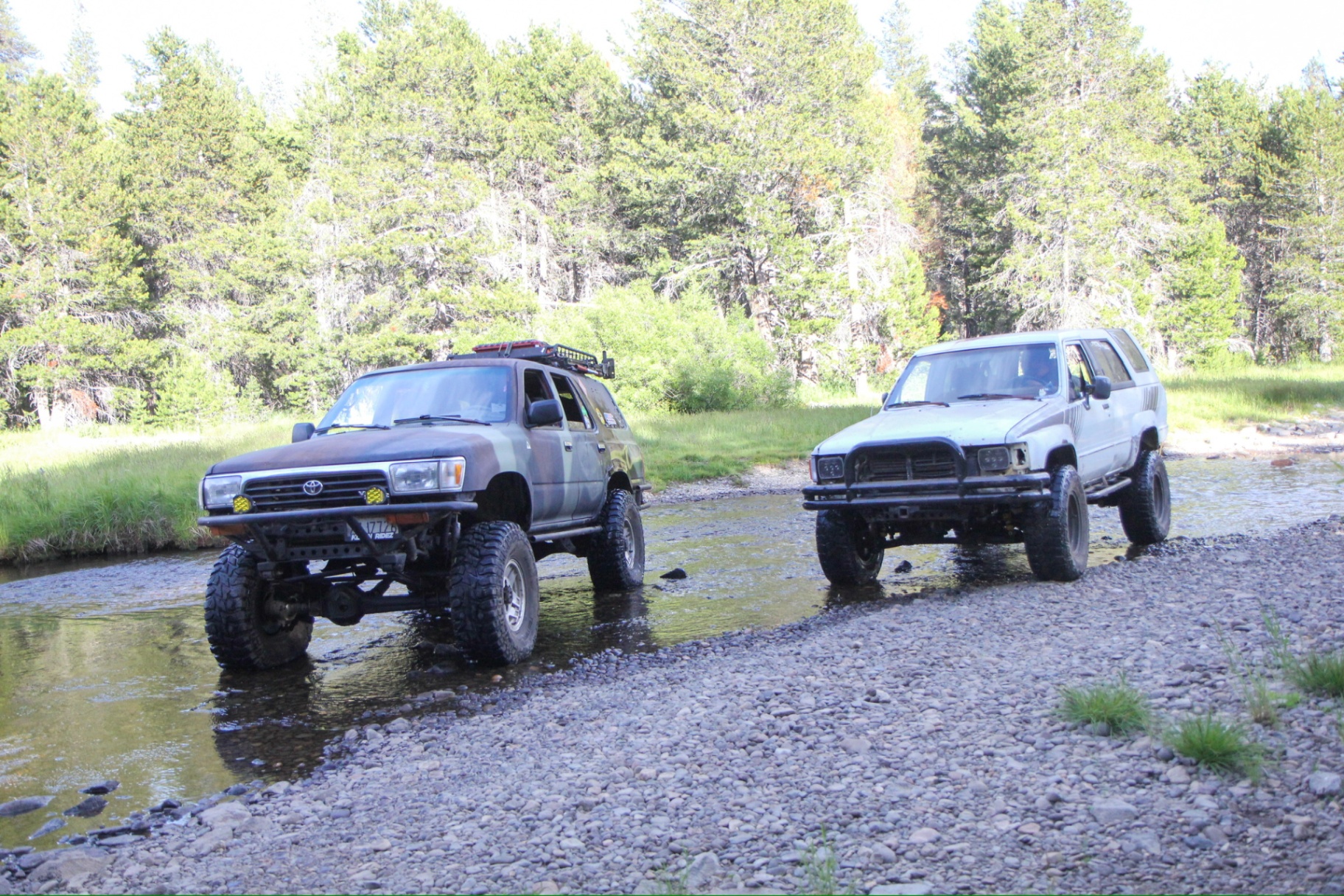 Two Toyota 4Runners crossing a river